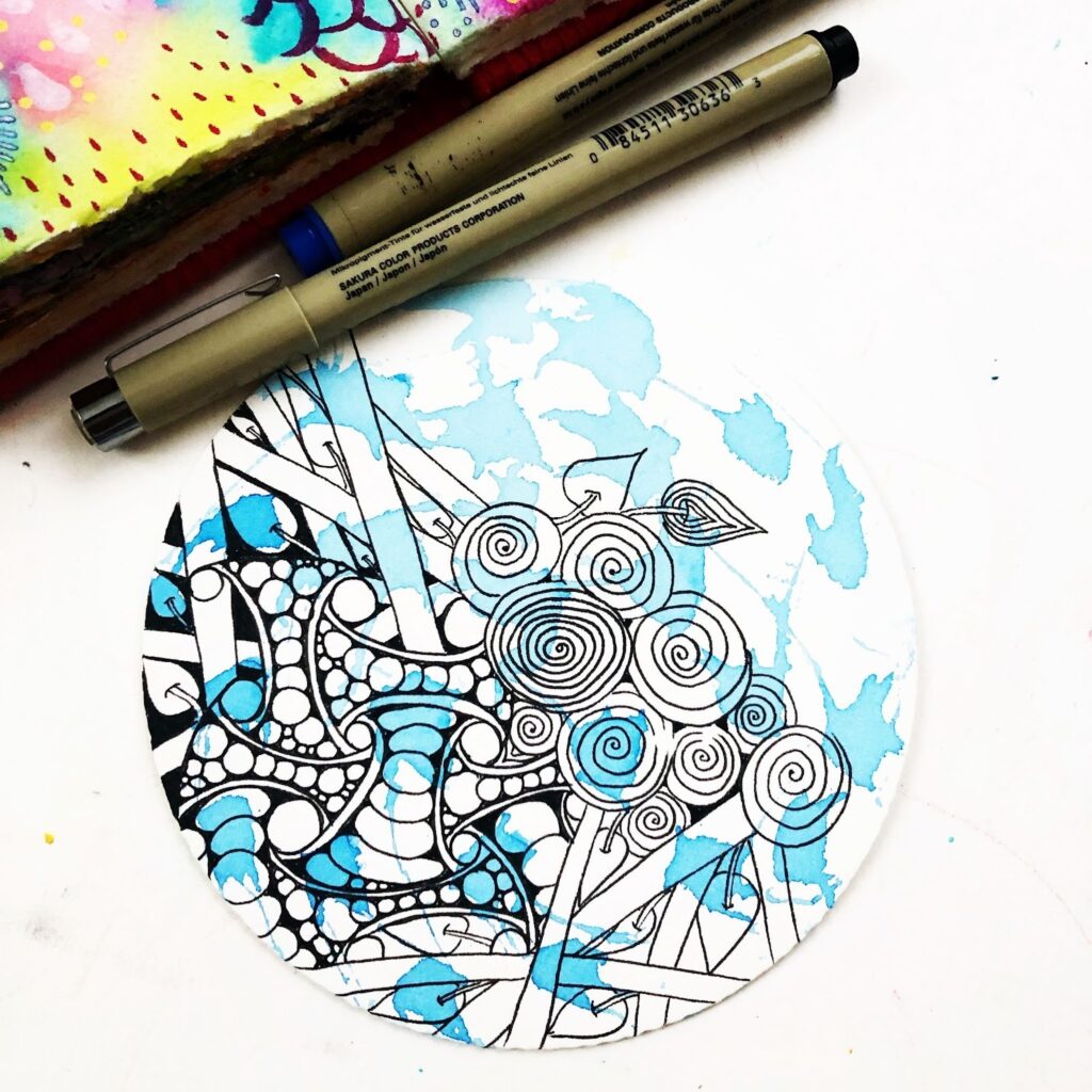 Zendala réalisé à l’encre noire et à l’aquarelle bleue, combinant motifs Zentangle et formes organiques, dans une pratique artistique personnelle après certification