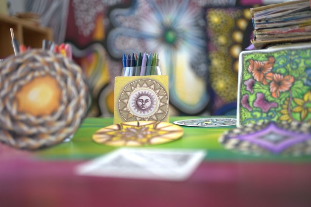 Matériel de dessin et créations Zentangle colorées sur une table lors d’un cours de Zentangle en ligne dans la communauté créative Jijihook.