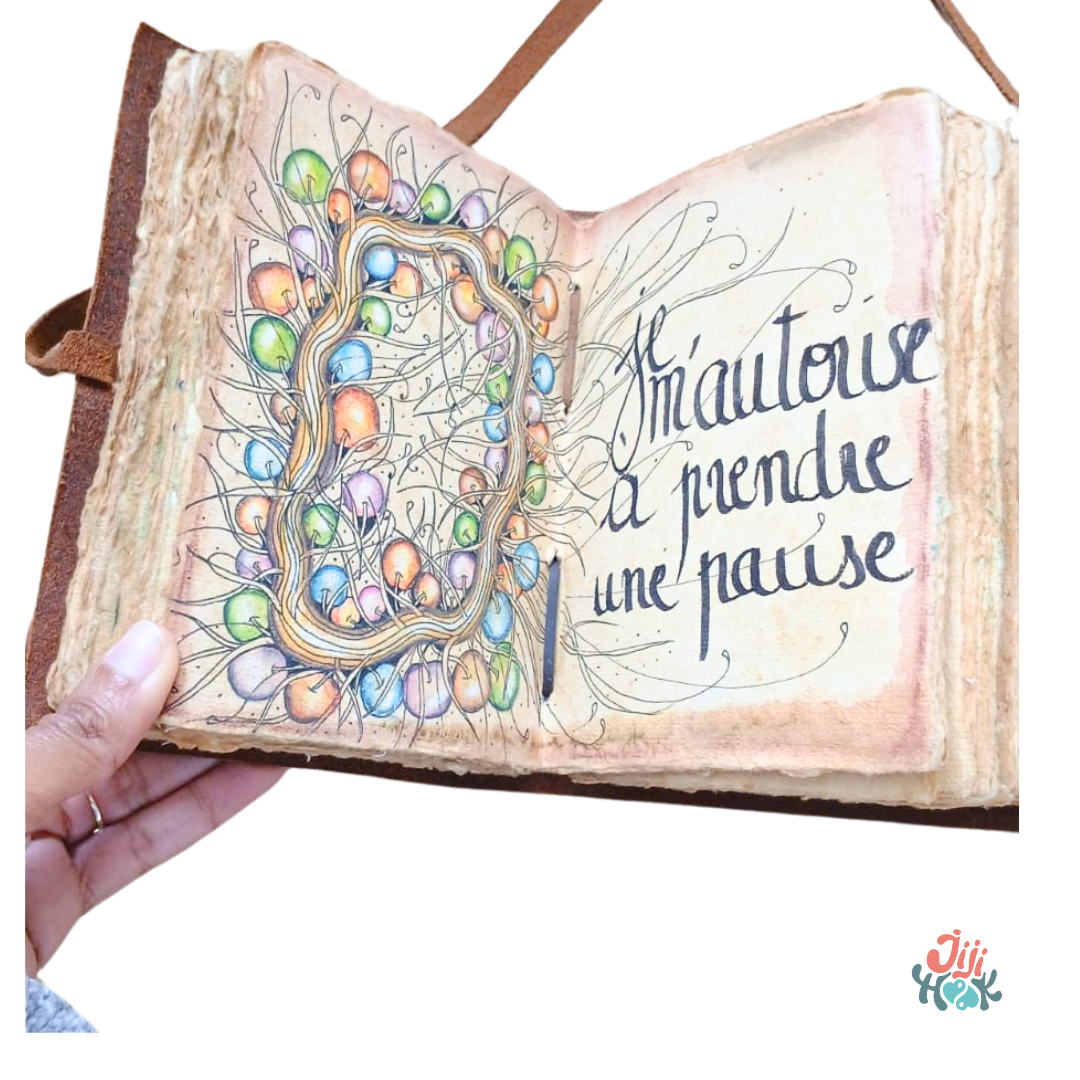 Carnet en cuir Moonster ouvert montrant une page zentangle illustrée de boules colorées et la phrase calligraphiée Je m'autorise à prendre une pause