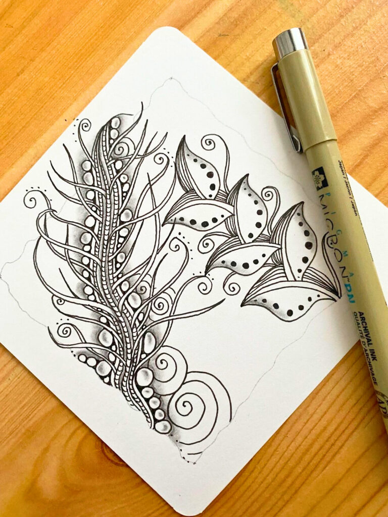 Motif Zentangle Foundabout dessiné à l’encre noire sur papier blanc, avec détails d’ombres au crayon et stylos Sakura Pigma Micron visibles sur la photo. Tutoriel artistique issu du blog créatif Jijihook.