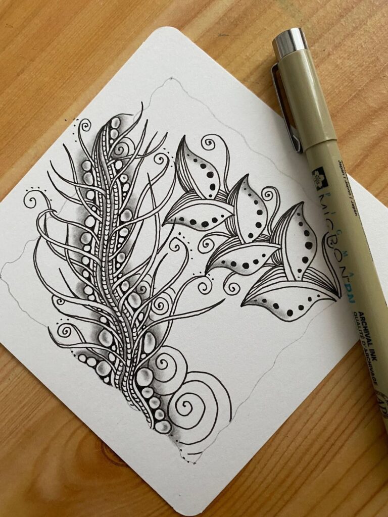Motif Zentangle Foundabout dessiné à l’encre noire sur papier blanc, avec détails d’ombres au crayon et stylos Sakura Pigma Micron visibles sur la photo. Tutoriel artistique issu du blog créatif Jijihook.